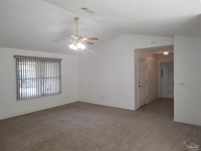 empty room featuring ceiling fan, lofted ceiling, carpet, and a textured ceiling