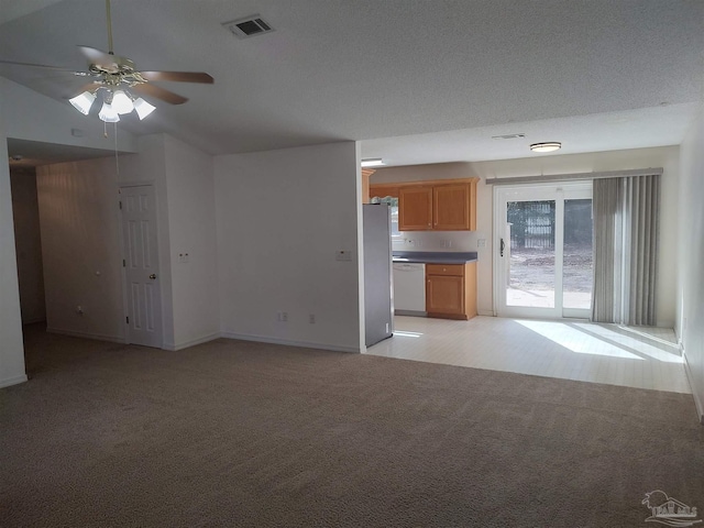 unfurnished living room with light carpet, a textured ceiling, and ceiling fan