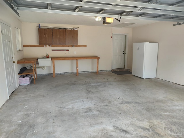 garage featuring white refrigerator, a garage door opener, and sink