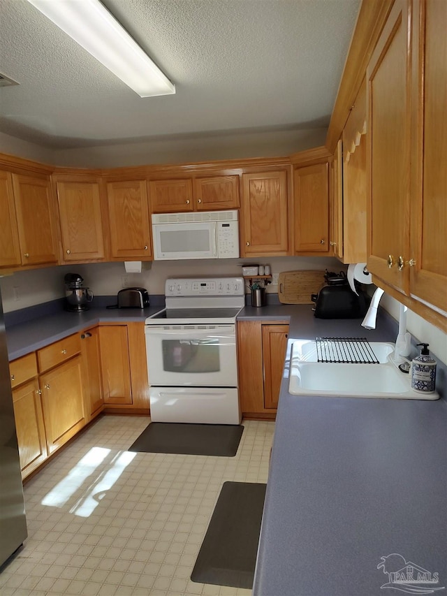 kitchen with a textured ceiling and white appliances