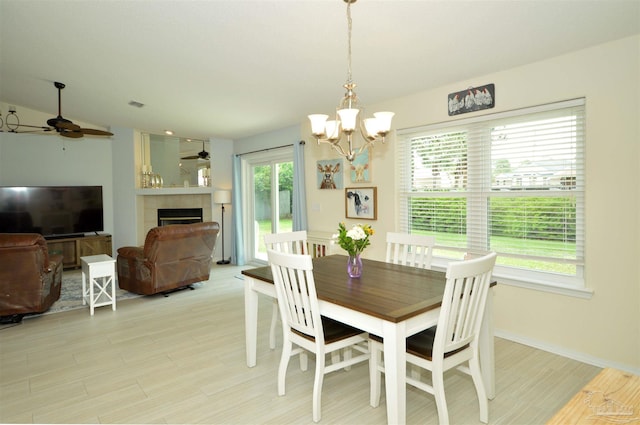 5735 Farrel Way, Milton, FL 32583 - dining room with a ceiling fan, a chandelier, light wood-type flooring, a fireplace, and baseboards