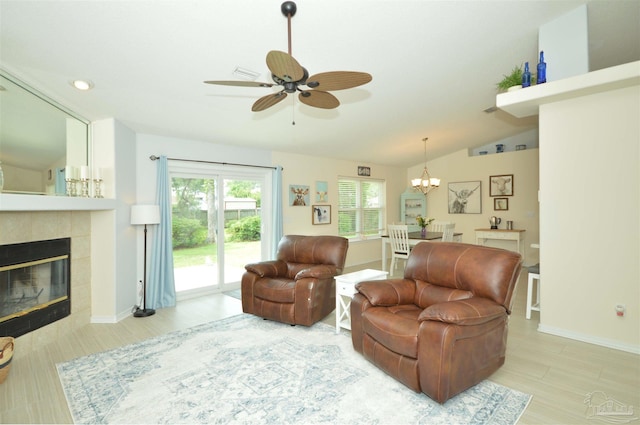 5735 Farrel Way, Milton, FL 32583 - living room featuring a ceiling fan, light wood-type flooring, a tiled fireplace, a chandelier, and vaulted ceiling