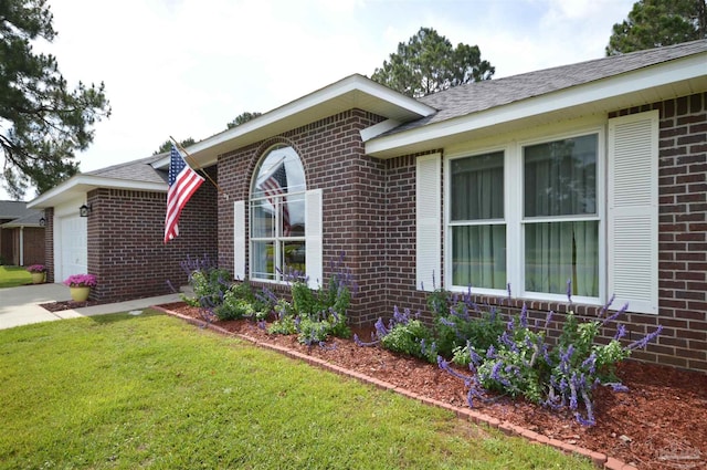 5735 Farrel Way, Milton, FL 32583 - view of side of home featuring brick siding, a yard, an attached garage, and roof with shingles