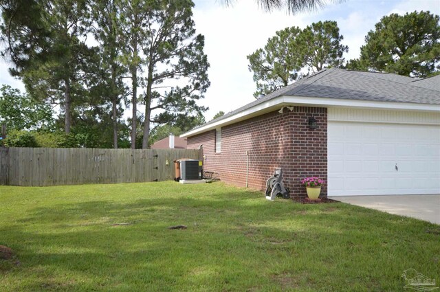 5735 Farrel Way, Milton, FL 32583 - view of side of home with brick siding, an attached garage, a shingled roof, driveway, and central AC unit