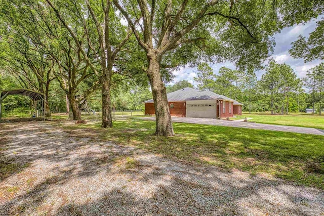 view of front of property with an attached garage, a front lawn, a detached carport, and asphalt driveway