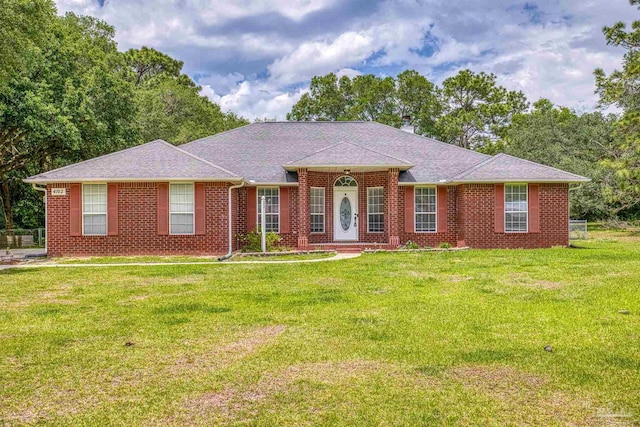 ranch-style house featuring a front yard, brick siding, and roof with shingles