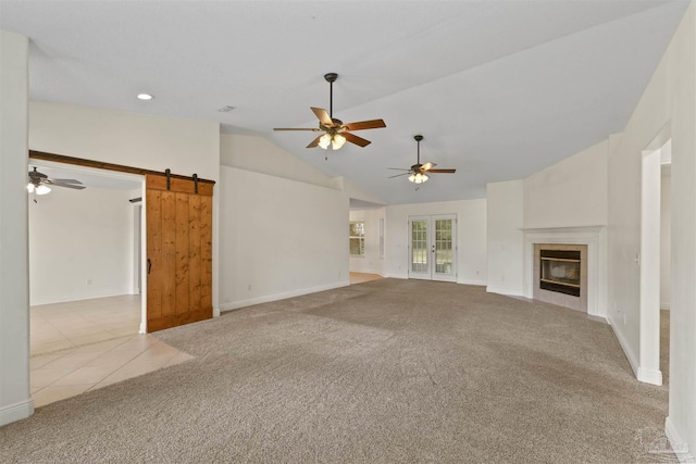 unfurnished living room with ceiling fan, carpet floors, vaulted ceiling, a fireplace, and baseboards