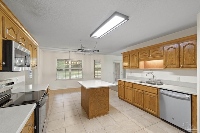 kitchen with stainless steel appliances, a sink, light countertops, a center island, and brown cabinetry
