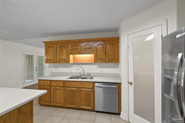 kitchen featuring a sink, stainless steel appliances, light countertops, and brown cabinetry