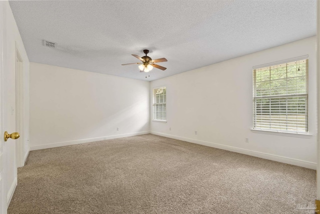unfurnished room with a ceiling fan, light carpet, baseboards, and a textured ceiling