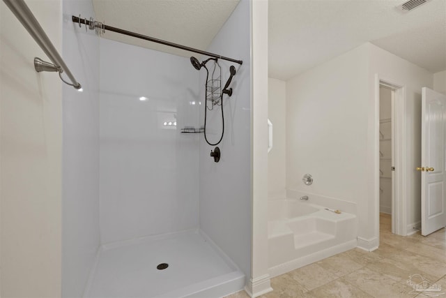 full bathroom with a shower, a textured ceiling, a bath, and baseboards
