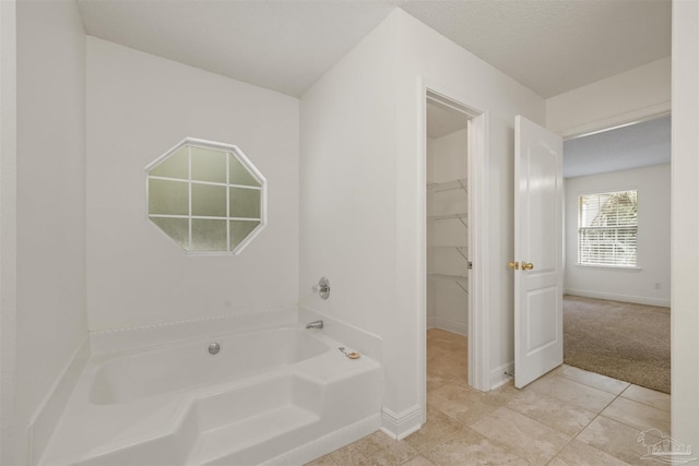 full bathroom with a bath, tile patterned floors, and baseboards