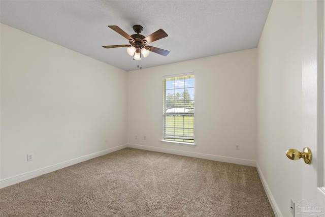 unfurnished room featuring light carpet, ceiling fan, baseboards, and a textured ceiling