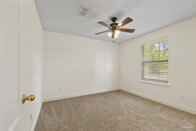 spare room featuring carpet floors, a ceiling fan, a textured ceiling, and baseboards