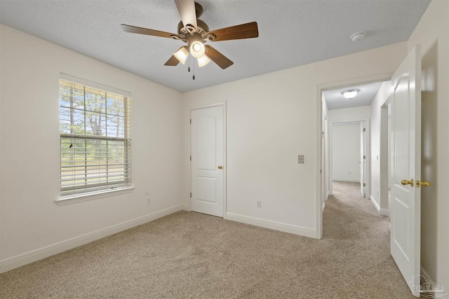 unfurnished bedroom with carpet flooring, baseboards, ceiling fan, and a textured ceiling