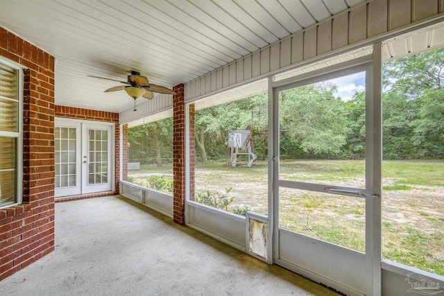 unfurnished sunroom featuring a ceiling fan and french doors