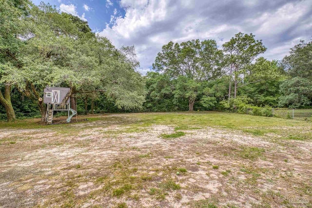 view of yard with a view of trees, fence, and an outdoor structure