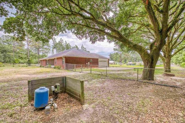 view of yard featuring fence and an attached garage