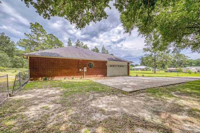 view of home's exterior with concrete driveway, an attached garage, brick siding, and roof with shingles