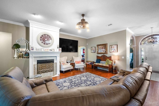 living room featuring a premium fireplace, dark wood-type flooring, and crown molding