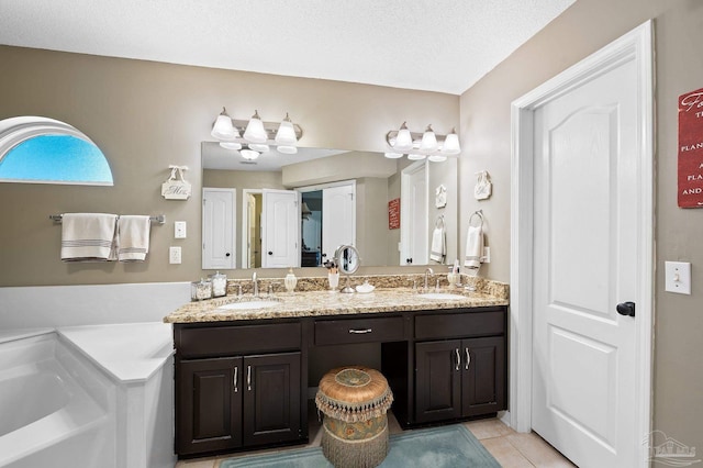 bathroom featuring a textured ceiling, tile patterned flooring, vanity, and a washtub