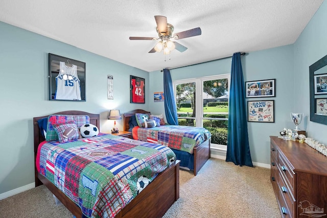 carpeted bedroom featuring ceiling fan and a textured ceiling