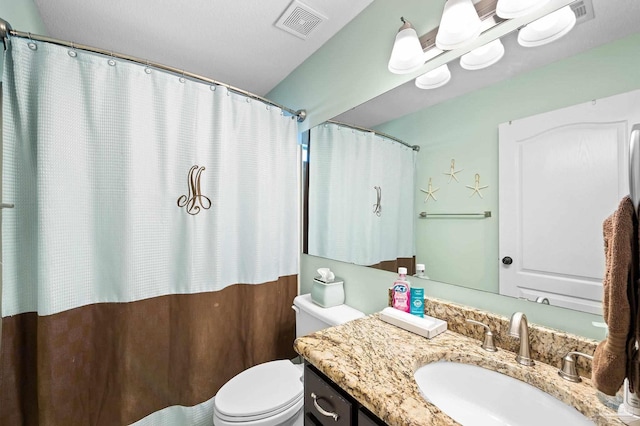 bathroom featuring curtained shower, vanity, and toilet