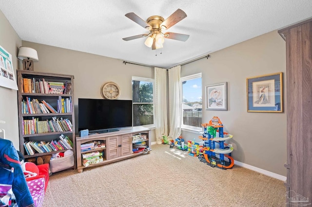 game room featuring ceiling fan, carpet flooring, and a textured ceiling