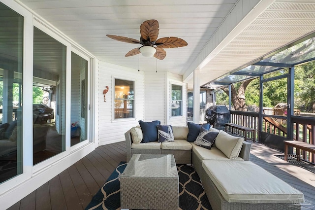 deck with ceiling fan, an outdoor living space, and a sunroom