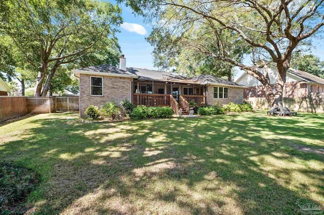 rear view of house with a lawn and a deck