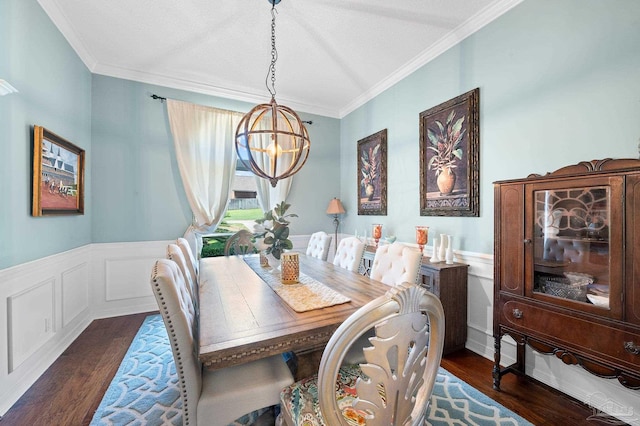 dining area with an inviting chandelier, crown molding, and dark hardwood / wood-style flooring