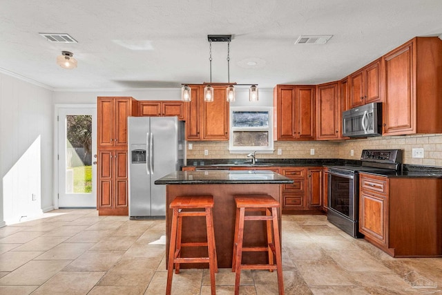 kitchen with a wealth of natural light, appliances with stainless steel finishes, a sink, and a center island