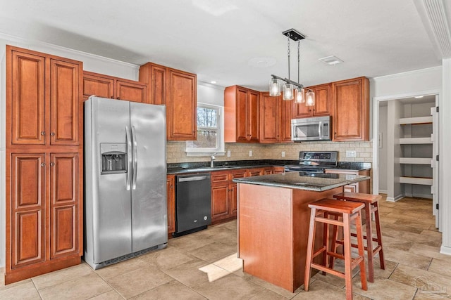 kitchen featuring a sink, a kitchen island, appliances with stainless steel finishes, backsplash, and brown cabinetry