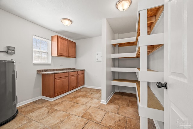 laundry room featuring water heater and baseboards