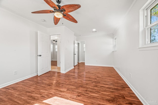 unfurnished bedroom featuring ornamental molding, a ceiling fan, baseboards, and wood finished floors