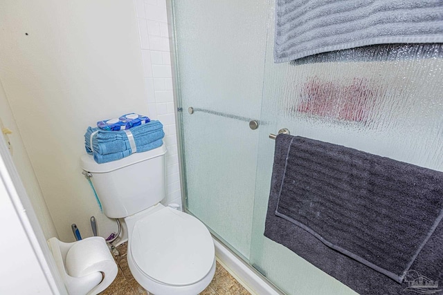 bathroom featuring a shower stall and toilet