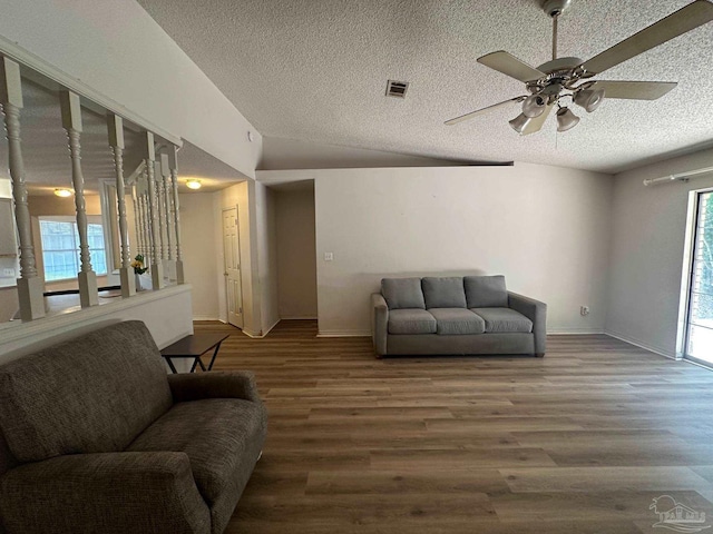 living room featuring lofted ceiling, wood-type flooring, ceiling fan, and a textured ceiling