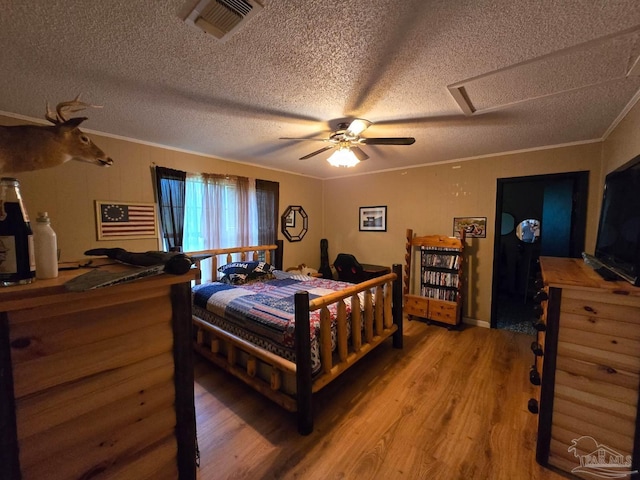 4940 Dawson Rd, Century, FL 32535 - bedroom with visible vents, a textured ceiling, crown molding, attic access, and light wood-style flooring