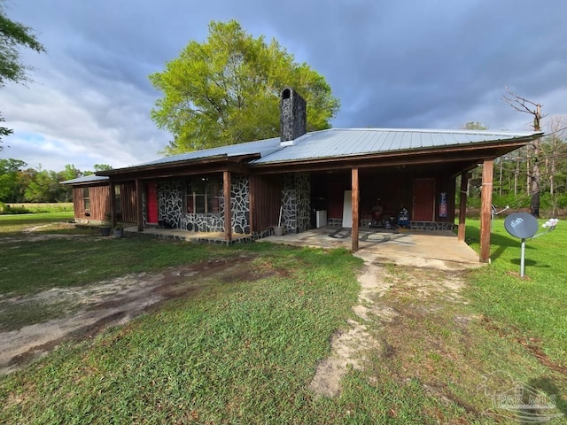 4940 Dawson Rd, Century, FL 32535 - rear view of property with a carport, a yard, metal roof, and a chimney