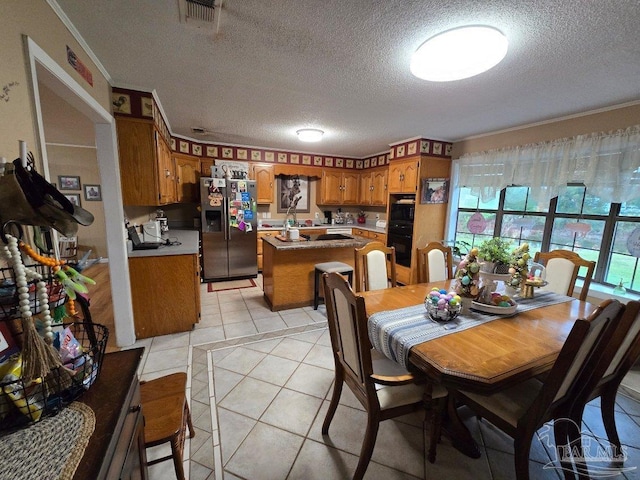 4940 Dawson Rd, Century, FL 32535 - dining space with a textured ceiling, light tile patterned flooring, ornamental molding, and visible vents