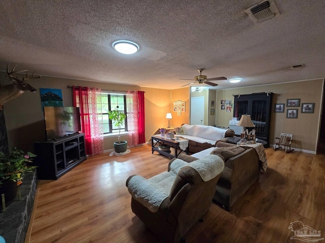 4940 Dawson Rd, Century, FL 32535 - living room with ceiling fan, a textured ceiling, visible vents, wood finished floors, and baseboards