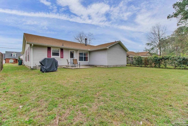 rear view of property with a yard, a patio, and fence