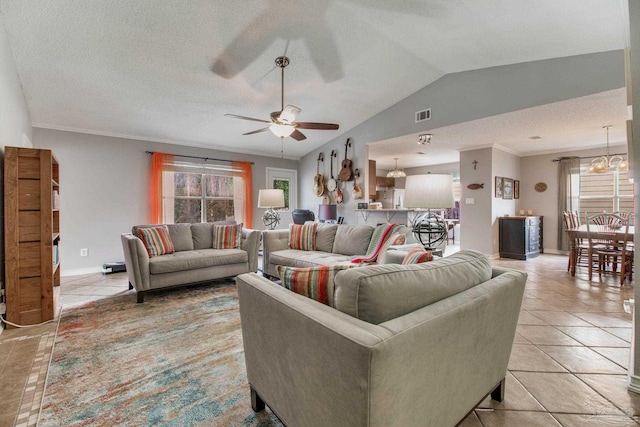 living room with vaulted ceiling, a wealth of natural light, light tile patterned floors, and visible vents