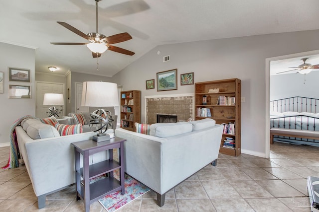 living area featuring lofted ceiling, ceiling fan, light tile patterned floors, a fireplace, and visible vents