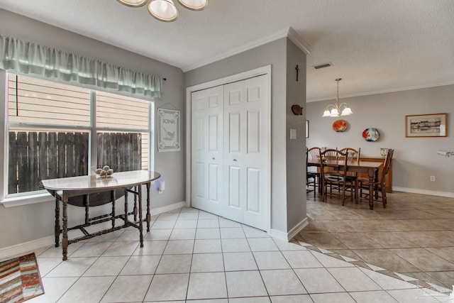 interior space with light tile patterned floors, a textured ceiling, visible vents, ornamental molding, and an inviting chandelier