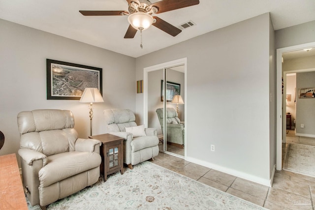 sitting room featuring light tile patterned floors, ceiling fan, visible vents, and baseboards