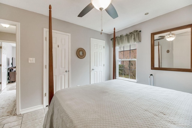 bedroom with multiple closets, a ceiling fan, baseboards, and light tile patterned floors