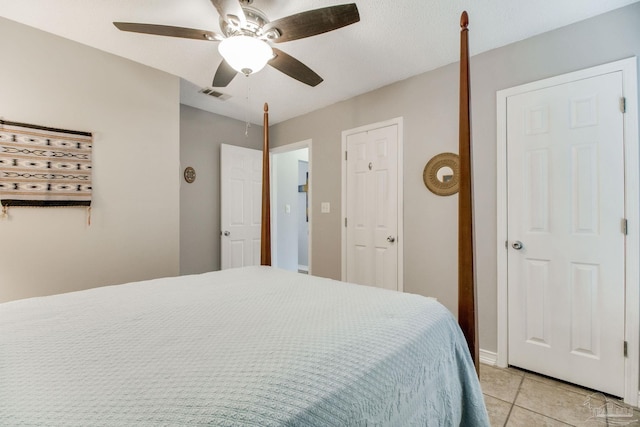 bedroom featuring light tile patterned flooring, visible vents, and a ceiling fan