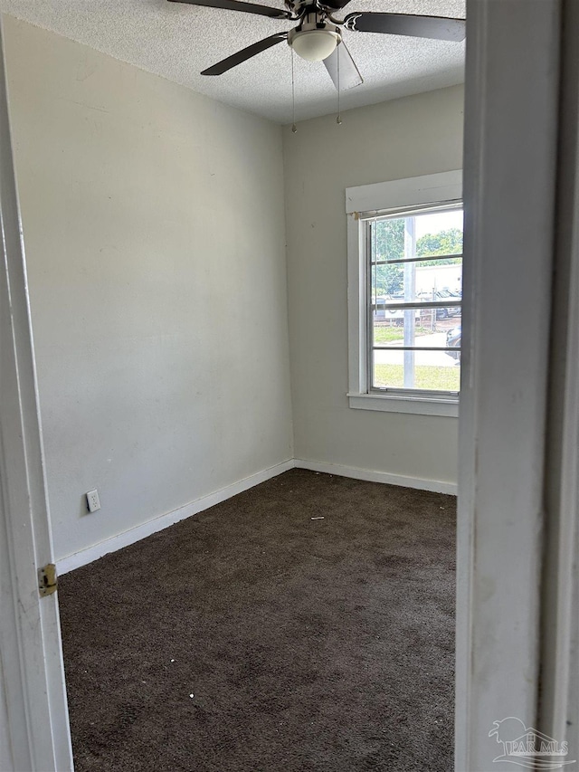 carpeted empty room featuring ceiling fan and a textured ceiling