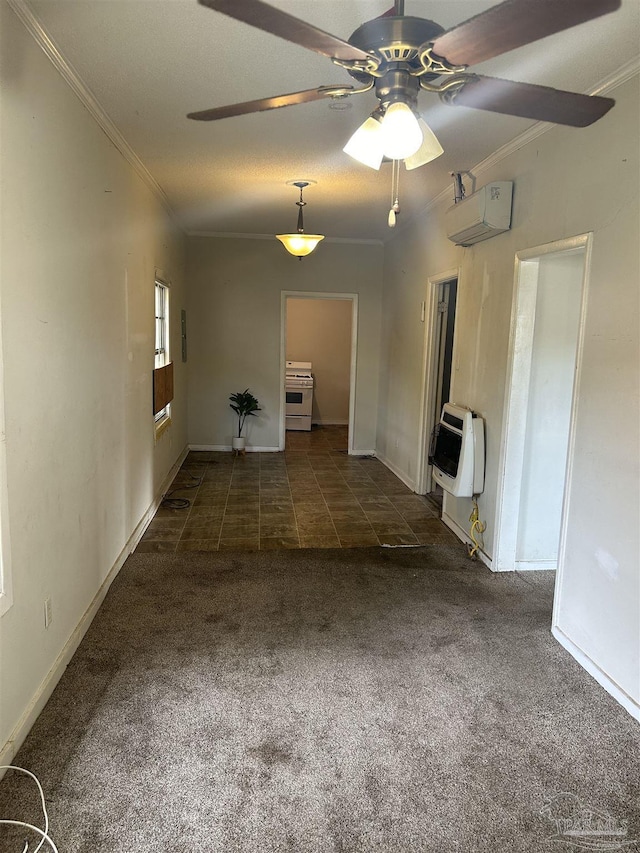 empty room with heating unit, a textured ceiling, ornamental molding, dark carpet, and ceiling fan